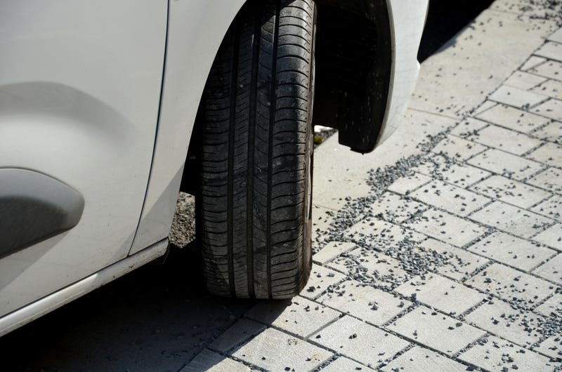 Closeup of wheel of car parked on sidewalk