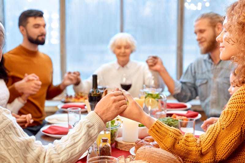 People holding with hands, praying before eating