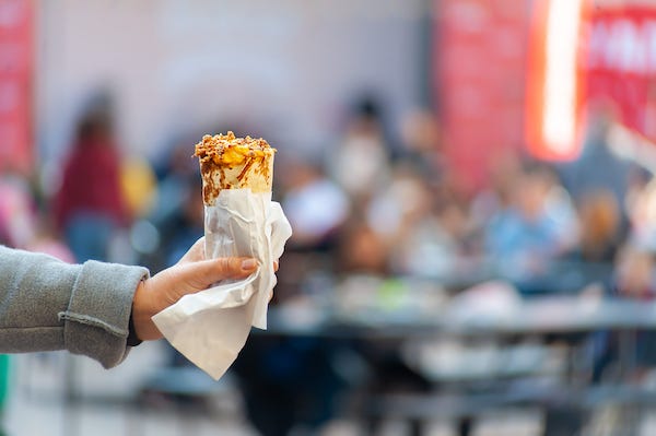 Woman holding burrito against a blurred background