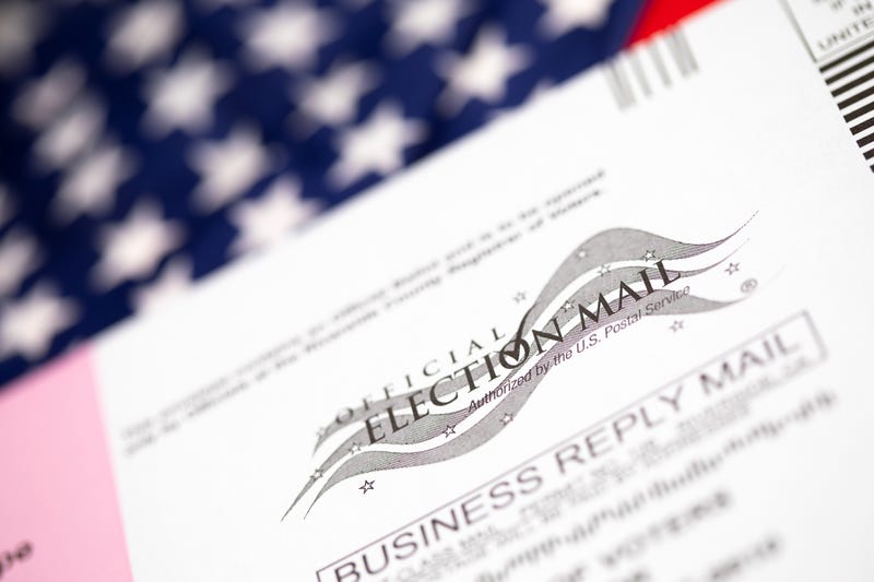 Vote-By-Mail Ballot Envelope Laying on American Flag.