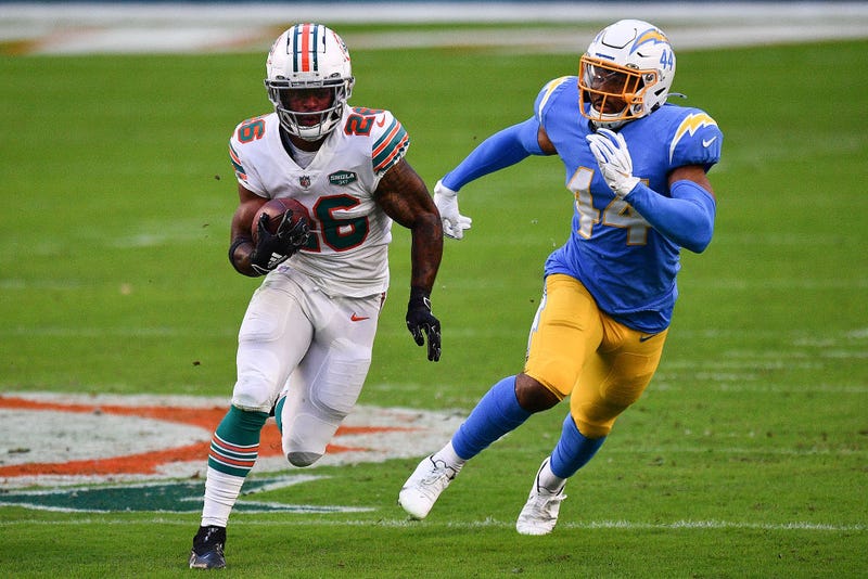 Salvon Ahmed sprints past a Chargers defender.