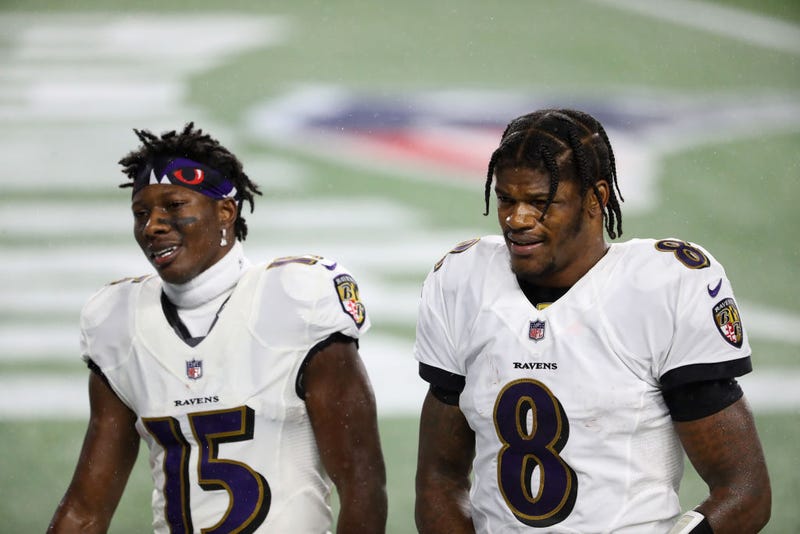 Marquise Brown and Lamar Jackson walk off the field together.