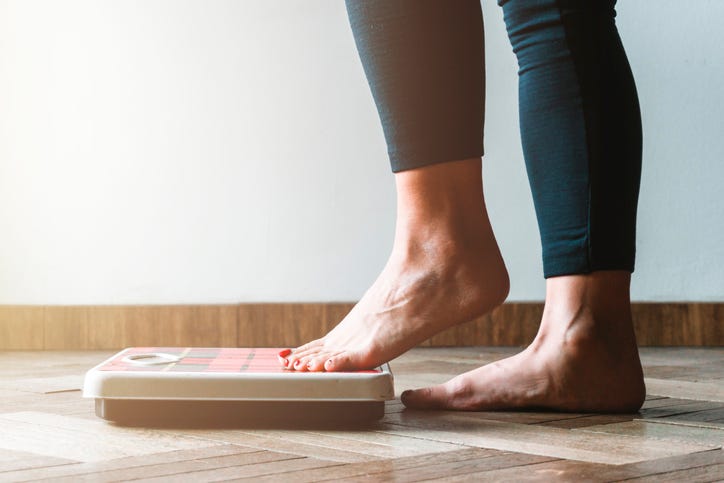 Person getting on a scale. 