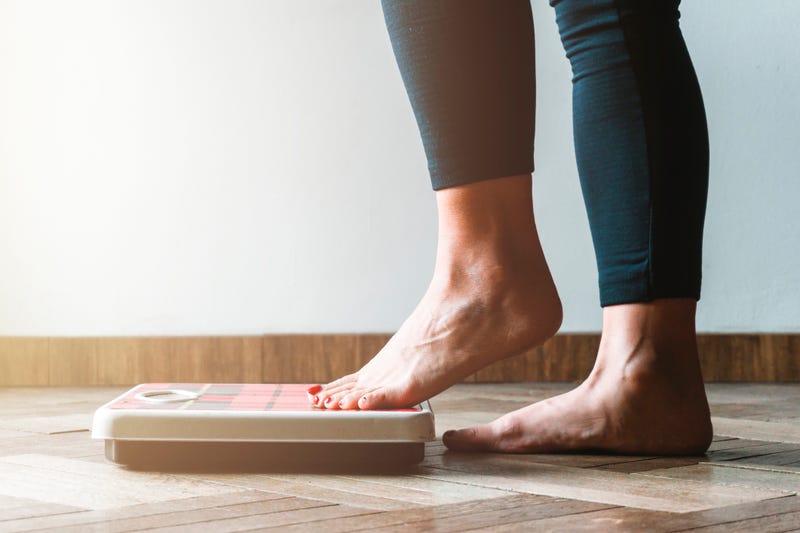 Person checking their weight on a scale. 