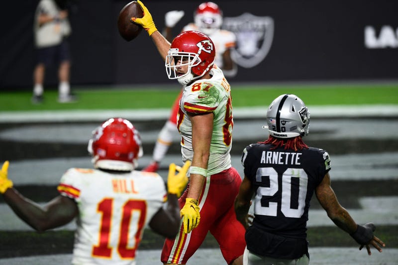Travis Kelce holds up the football after catching a game-winning touchdown.