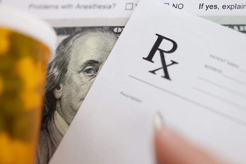 Dollar bill and doctors prescription are on doctors table in clinic closeup.