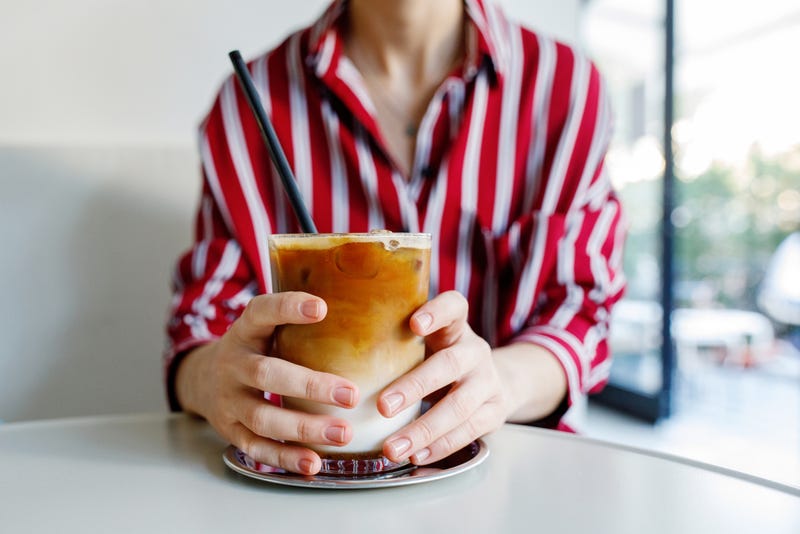 Woman holding iced pumpkin spice latte. 