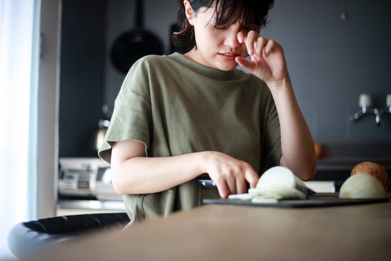 Woman cutting onions and crying