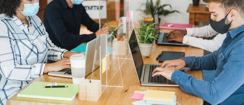 Workspace with plexiglass dividers to protect from COVID-19. 