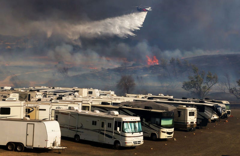 A firefighting helicopter drops water over the Bond Fire burning in the Silverado Canyon area of Orange County on December 3, 2020 near Irvine, California. The 4,000-acre wildfire broke out along with a number of other fires in Southern California amid gusty Santa Ana winds in the region. (Photo by Mario Tama/Getty Images)