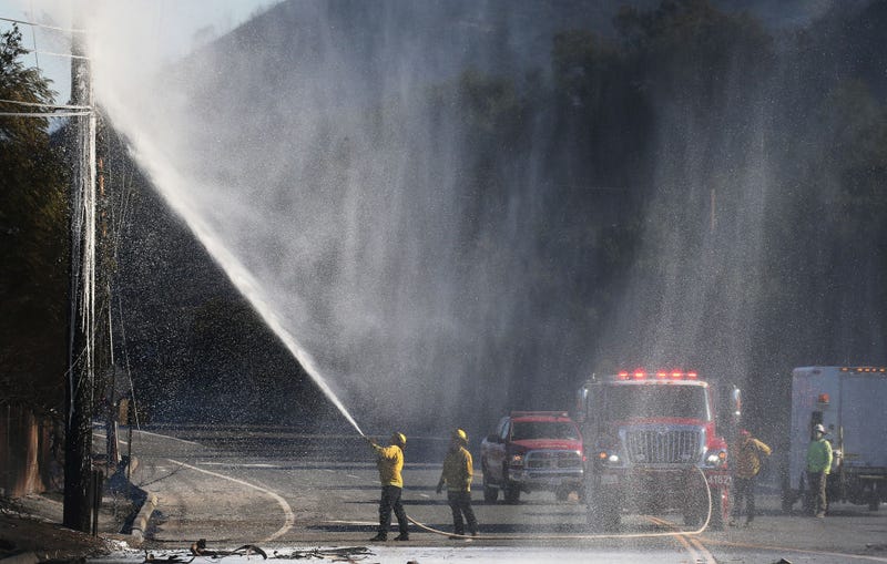 A firefighter extinguishes a burned power pole during the Bond Fire in the Silverado Canyon area of Orange County on December 3, 2020 near Irvine, California.