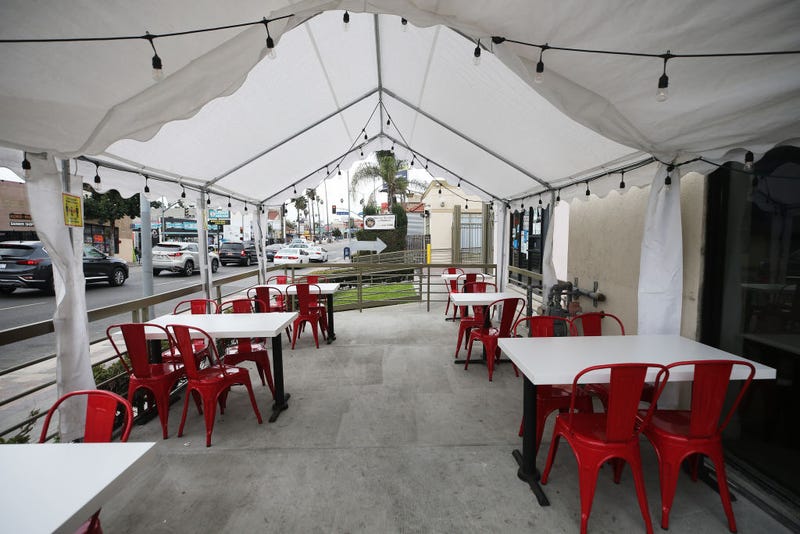 FILE - A tented area for outdoor restaurant dining stands empty on the first day of new stay-at-home orders on Dec. 7, 2020 in Los Angeles.