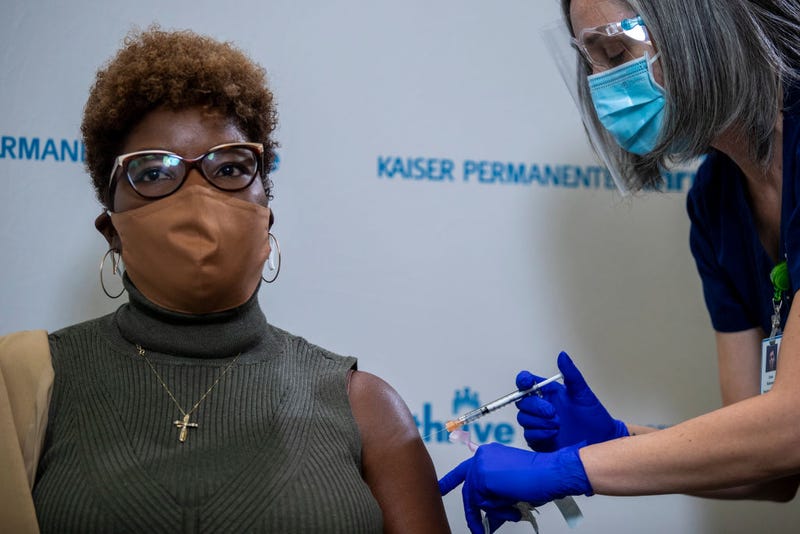 Kaiser Permanente registered nurse Corie Robinson administers the Pfizer COVID-19 vaccine to Kaiser Permanente nurse Sally Bing during a vaccine event.