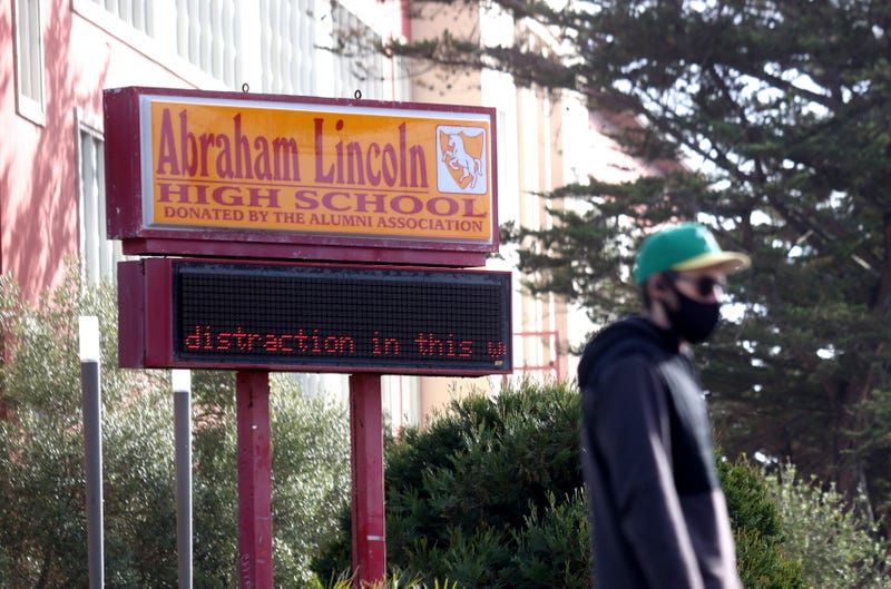 A pedestrian walks by a sign outside of Abraham Lincoln High School on December 17, 2020 in San Francisco, California.