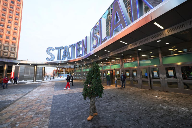 Tommy Liberto walks out of the Staten Island ferry terminal after arriving in NYC wearing a Christmas tree costume on December 18, 2020 in New York City.