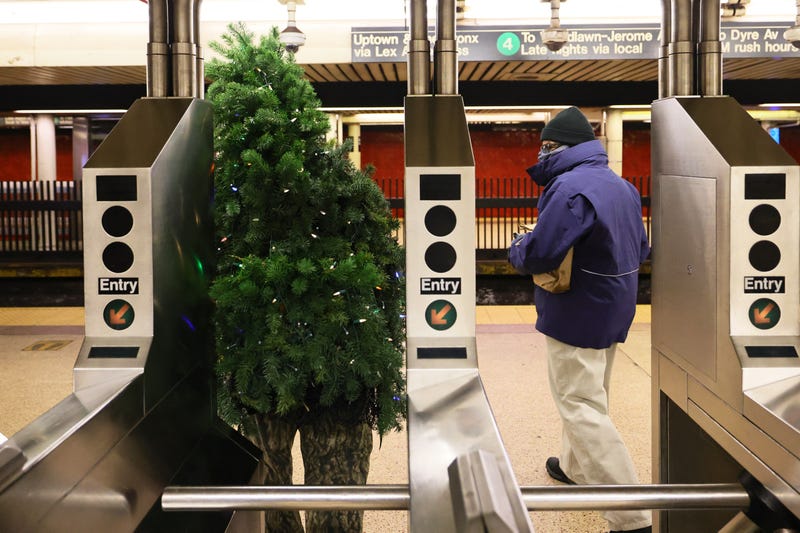 Tommy Liberto passes through a turnstile as he wears a Christmas tree costume in Lower Manhattan on December 18, 2020 in New York City. 