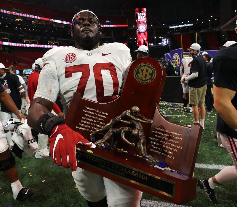 Alex Leatherwood #70 of the Alabama Crimson Tide carries the trophy after their 52-46 win over the Florida Gators in the SEC Championship at Mercedes-Benz Stadium on December 19, 2020 in Atlanta, Georgia
