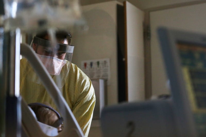 Registered nurse Eduardo Eran cares for a COVID-19 patient in the COVID-19 ward at Sharp Chula Vista Medical Center on December 21, 2020 in Chula Vista, California.