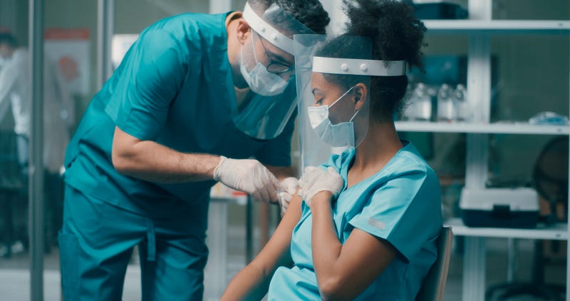 Hospital worker getting vaccinated stock photo.