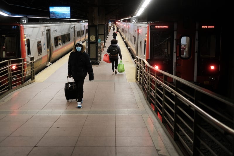 People walk along a train platform at Grand Central Terminal