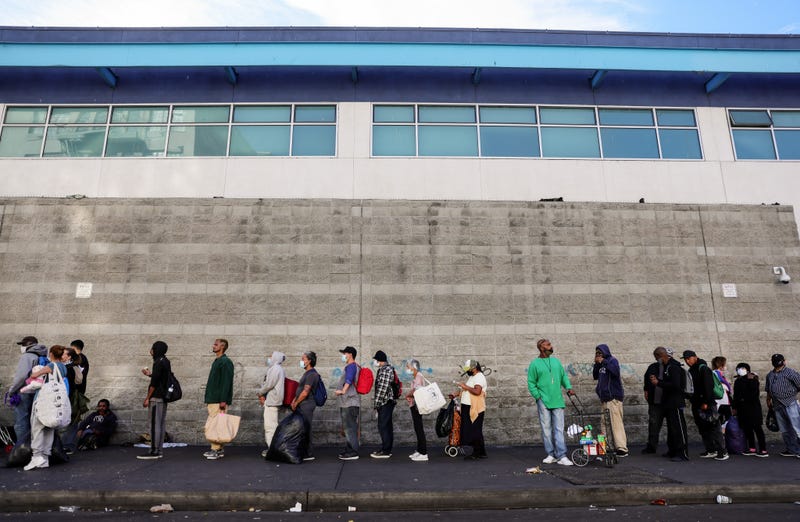 Community members wait in line to receive holiday-themed takeout meals and backpacks with toiletries from the Midnight Mission in Skid Row on Christmas day amid the COVID-19 pandemic on December 25, 2020 in Los Angeles, California.