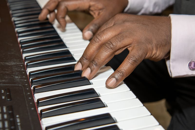 man's hands playing piano