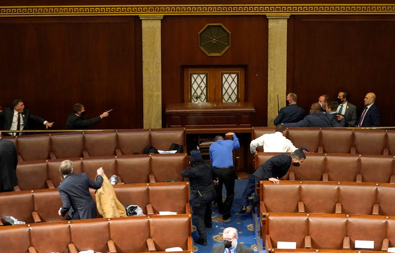 U.S. Capitol police officers point their guns at a door that was vandalized in the House Chamber during a joint session of Congress on January 06, 2021 in Washington, DC. Congress held a joint session today to ratify President-elect Joe Biden's 306-232 Electoral College win over President Donald Trump. A group of Republican senators said they would reject the Electoral College votes of several states unless Congress appointed a commission to audit the election results. 