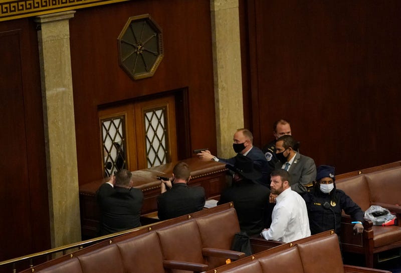 U.S. Capitol police officers point their guns at a door that was vandalized in the House Chamber during a joint session of Congress on January 06, 2021 in Washington, DC.