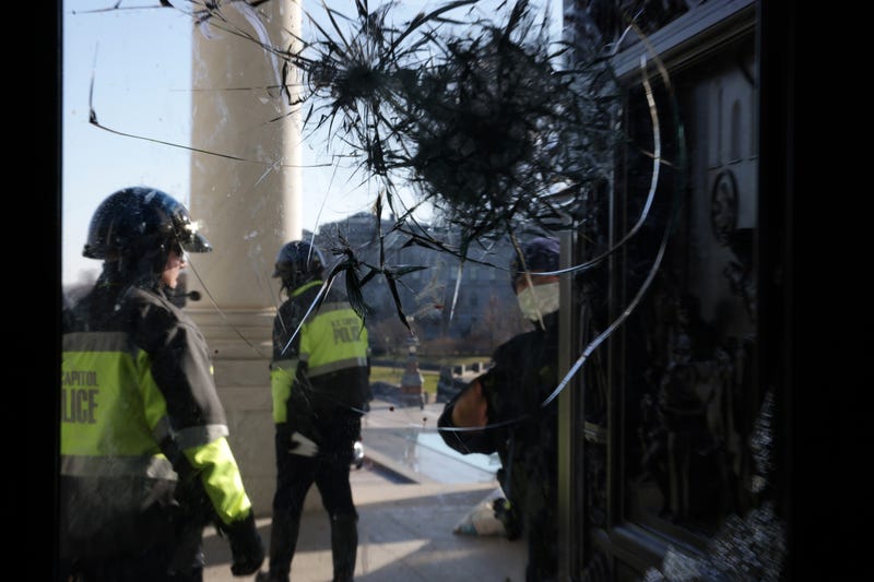 U.S. Capitol Police inspect a damaged entrance on Jan. 7, 2021.