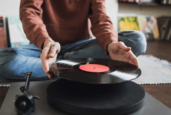 Man putting album onto record player