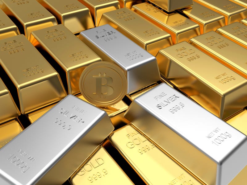 Rows of gold bars with bitcoin coin and silver bars