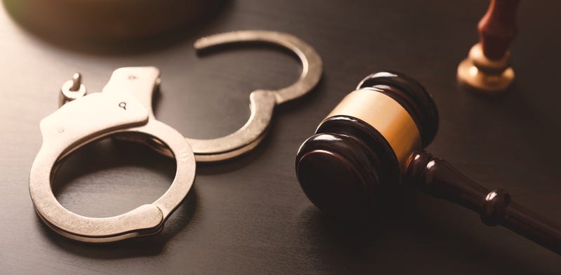 Handcuffs and gavel on a desk.