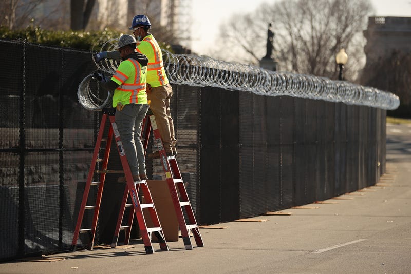 Workers put concertina razor wire along the top of the 8-foot 'non-scalable' fence that surrounds the U.S. Capitol the day after the House of Representatives voted to impeach President Donald Trump for the second time January 14, 2021 in Washington, DC. Thousands of National Guard troops have been activated to protect the nation's capital against threats surrounding President-elect Joe Biden’s inauguration and to prevent a repeat of last week’s deadly insurrection at the U.S. Capitol. 