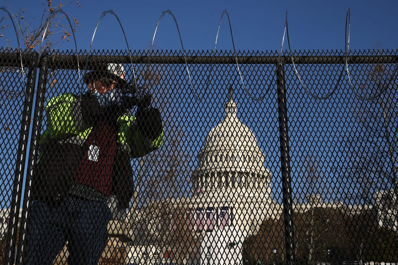 Workers put concertina razor wire along the top of the 8-foot 'non-scalable' fence that surrounds the U.S. Capitol the day after the House of Representatives voted to impeach President Donald Trump for the second time January 14, 2021 in Washington, DC. Thousands of National Guard troops have been activated to protect the nation's capital against threats surrounding President-elect Joe Biden’s inauguration and to prevent a repeat of last week’s deadly insurrection at the U.S. Capitol.
