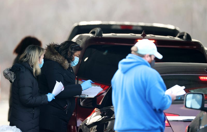 Workers help to facilitate arrivals at a drive-through COVID-19 vaccination site at Jones Beach State Park on January 14, 2021 in Wantagh, New York.
