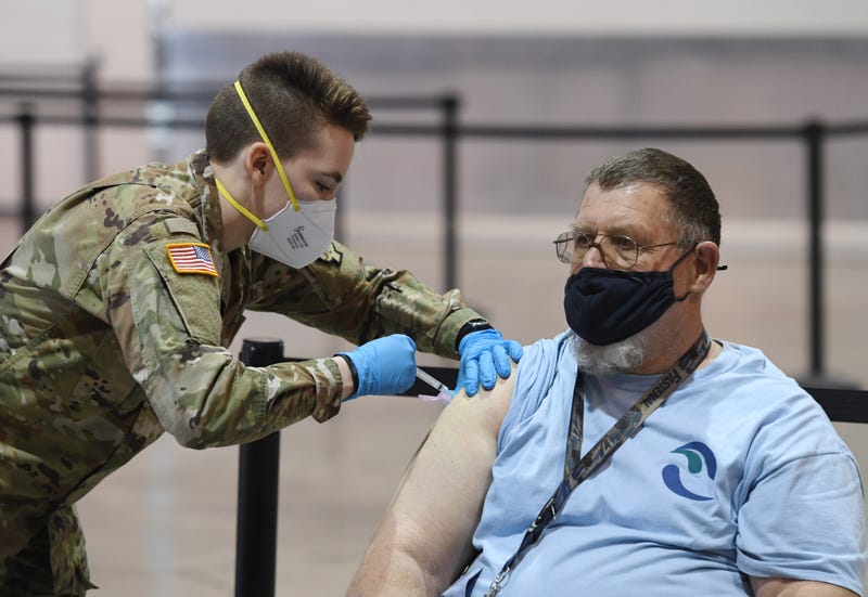 Spc. Katherine Deskins (L) of the Nevada Army National Guard administers a Moderna COVID-19 vaccination to Clark County Water Reclamation District mechanic Ray Anderson on the first day of Clark County's pilot vaccination program at Cashman Center on January 14, 2021