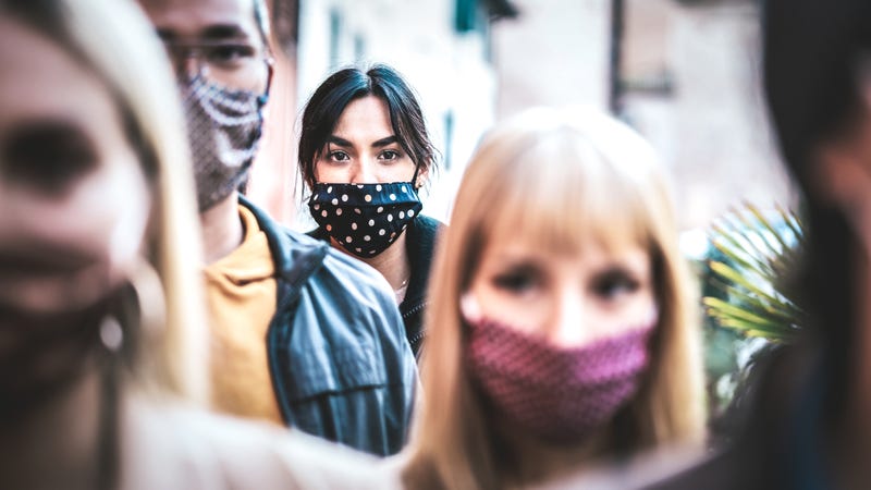 File photo of urban commuters in a crowd of people. All are wearing face masks.