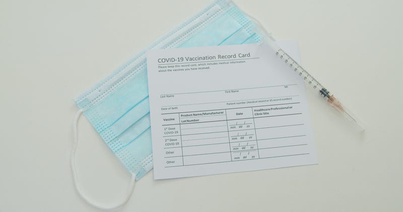 Vaccine, mask, and vaccine record card.