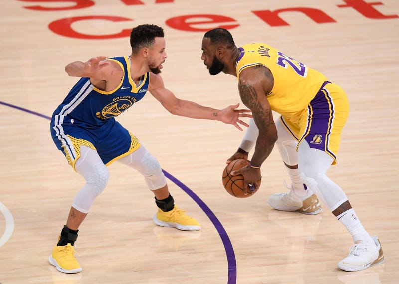 Lakers star LeBron James guarded by Warriors star Steph Curry.