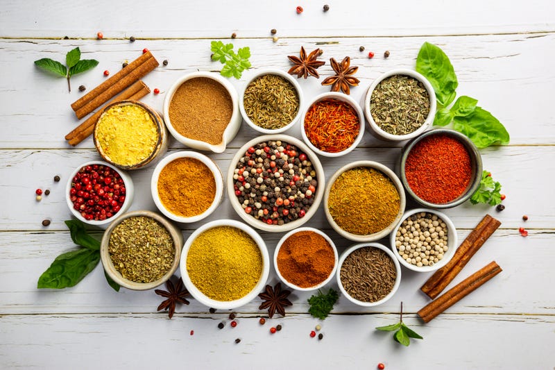 Herbs and spices in bowels over white wooden background
