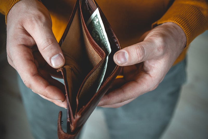 stock image: man opens a wallet that is mostly empty except for a $1 bill