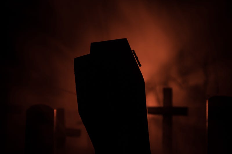 Scary coffin backed by red light and fog, stock photo. 