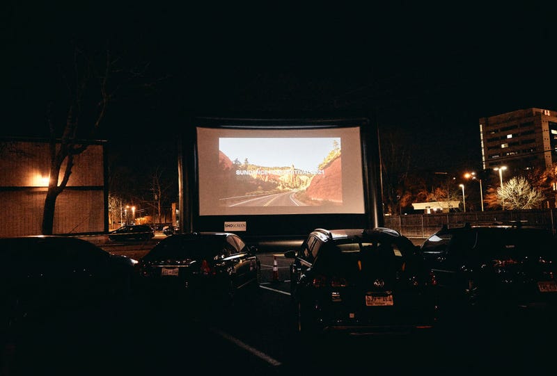 A drive-in screening is held in the parking lot of the Belcourt Theatre