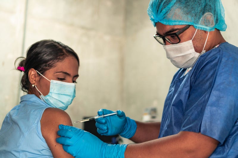 Young woman receiving Covid-19 vaccine at the doctor's office.