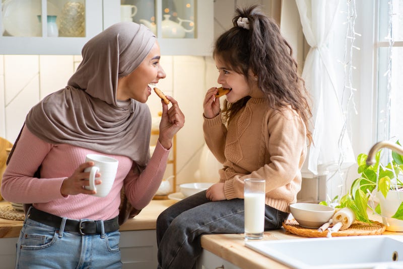 Mom and daughter eating cookies and milk 