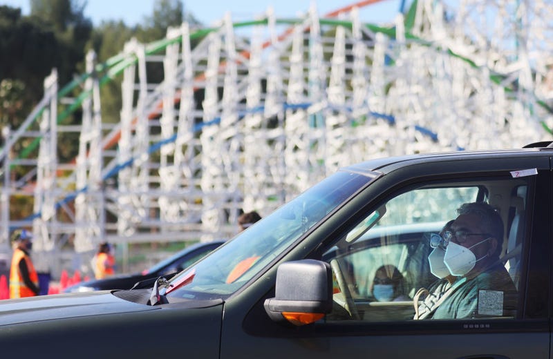 People wearing masks while parked outside Six Flags Magic Mountain.