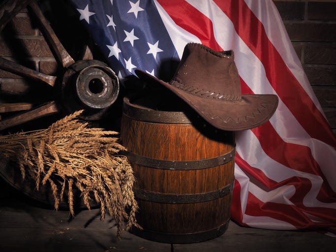 Wooden oak barrel and American flag on rustic background.