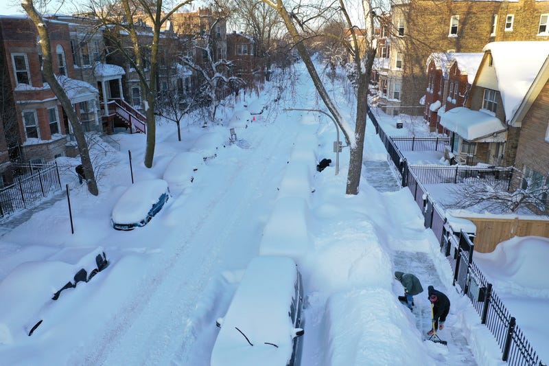 Residents clear snow from in front of their homes on February 16, 2021 in Chicago, Illinois. The city is digging out after a snowstorm dropped more than 17 inches of snow in the some areas of the city in the past 24 hours. 