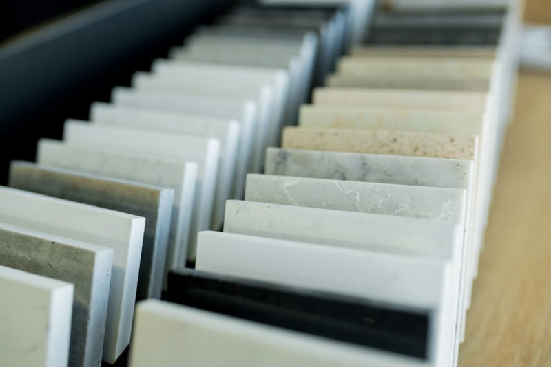 Close-up sample of stone for new kitchen countertop in showroom. Stock photo.