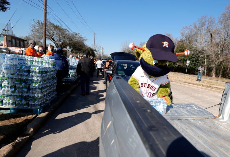 Orbit, the Houston Astros mascot, loads a case of water into a truck during a water distribution at the Astros Youth Academy on February 20, 2021 in Houston, Texas. Much of Texas is still struggling with historic cold weather, power outages and a shortage of potable water after winter storm Uri swept across 26 states with a mix of freezing temperatures and precipitation.